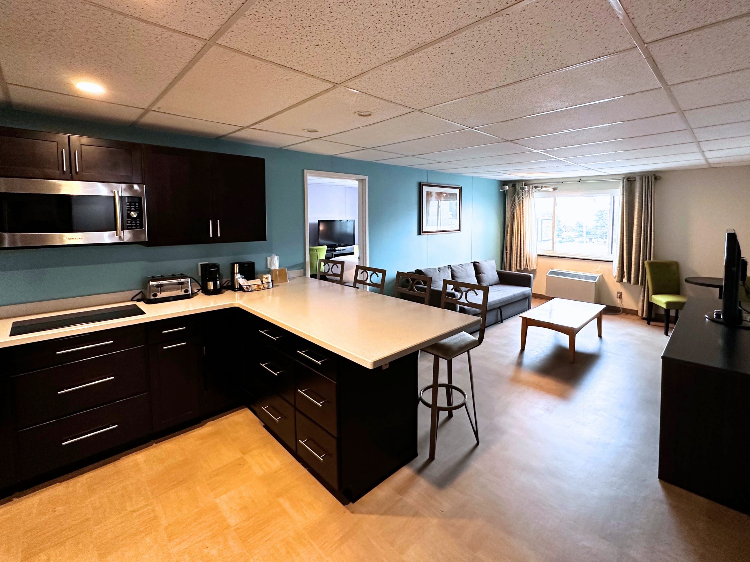 Spacious Family Suite at Expedition Lodge with two bedrooms, a living room, and a kitchenette, ideal for family stays.